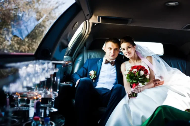 Bride and groom sitting inside a luxury wedding limo car, enjoying premium wedding transportation service.