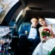 Bride and groom sitting inside a luxury wedding limo car, enjoying premium wedding transportation service.